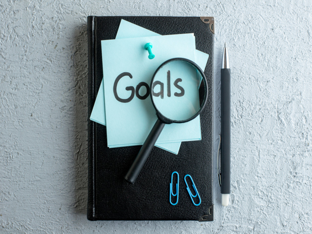 Image of a planner open to a goals section, featuring organized notes and colorful markers, emphasizing the importance of focus on goals for productivity.